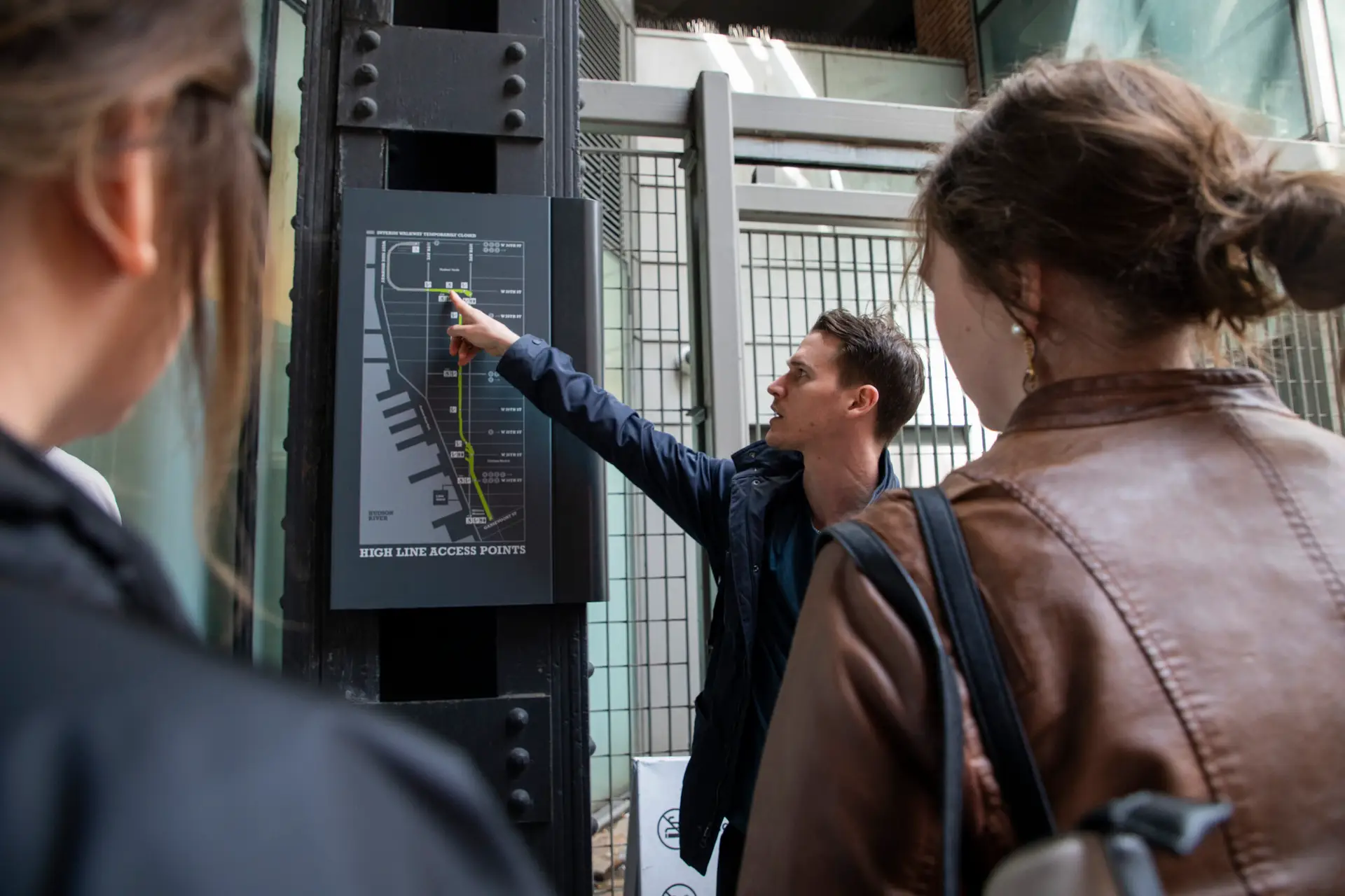 a man showing a group of people the map of the high line in nyc