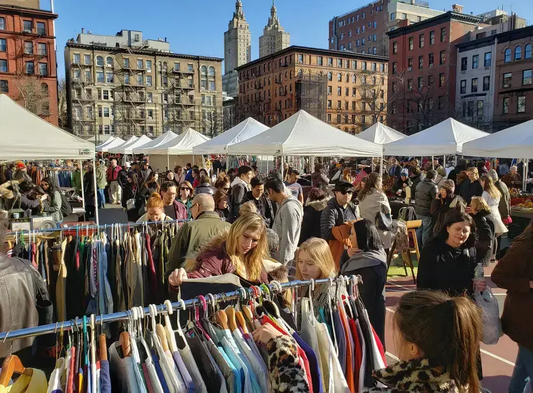 a group of people shopping at an outdoor flea marke