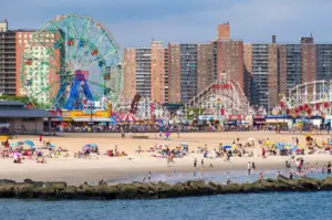 amusement park at the beach with city buildings behind it