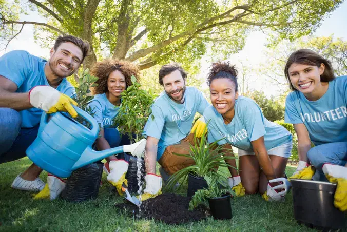 group of people working outside and smiling at the camera