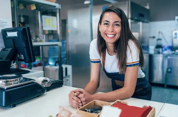 Here's why you should patronize local businesses versus corporate chains | Like A Local Tours a woman smiling near a cash register