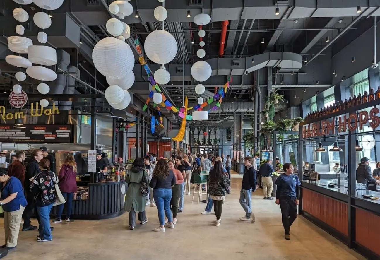 a group of people walking around a food market