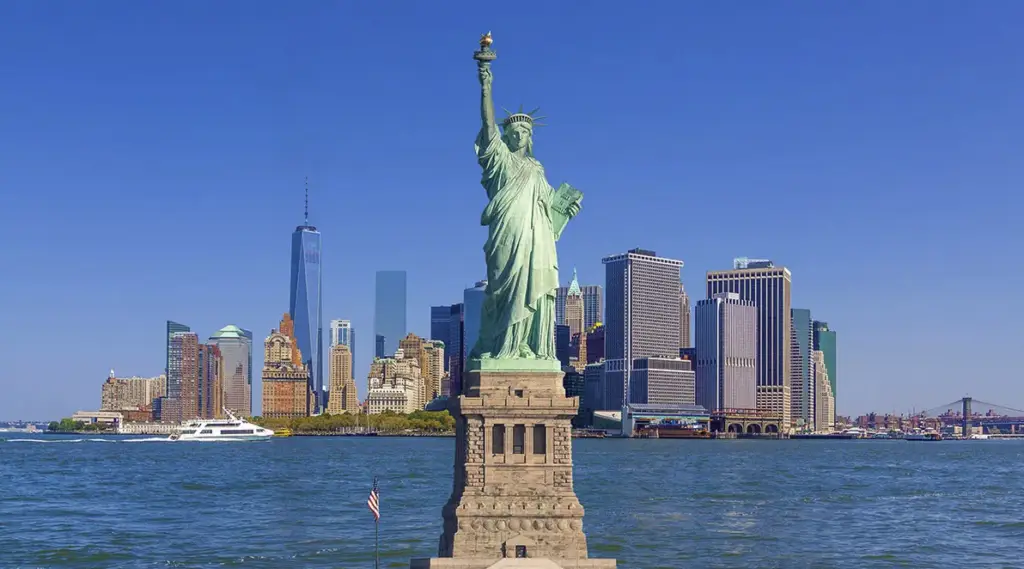 statue of liberty with lower manhattan buildings in the background