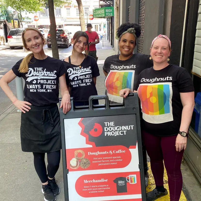 The Story of The Doughnut Project | Like A Local Tours four women posing for the camera wearing doughnut project shirts