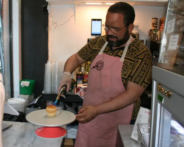 Finding Heaven in Hell's Kitchen on our Hell's Kitchen Tour | Like A Local Tours a man standing in a kitchen preparing food