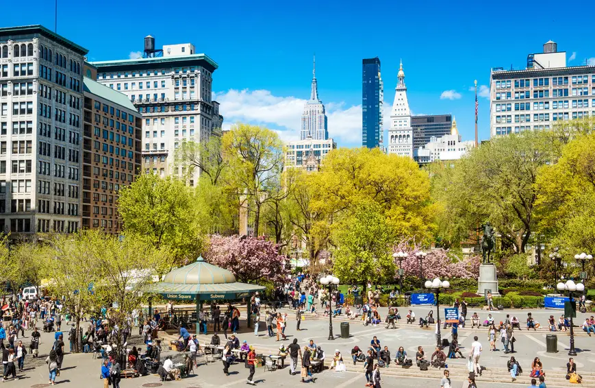 Discovering The Charm of Flatiron and Union Square | Like A Local Tours a group of people riding skis on a snowy road in Union Square, Manhattan