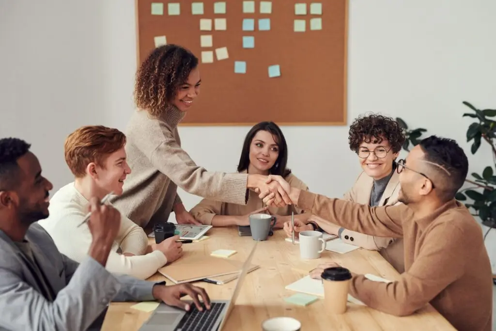 a group of workmates sitting at a table showing team work