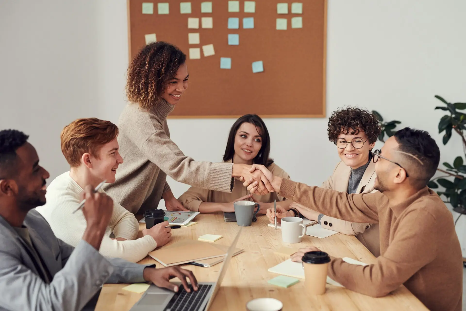 a group of workmates sitting at a table showing team work