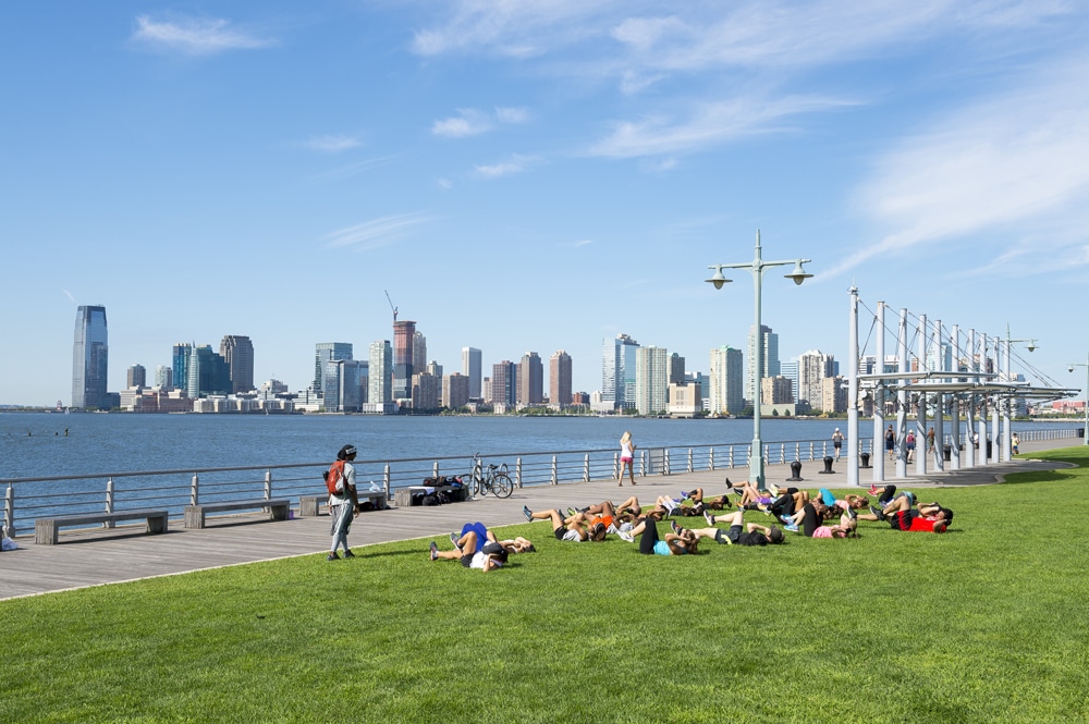 a group of people in a field near a body of water