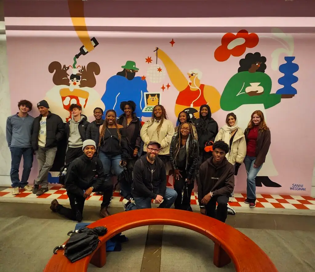 a group of people in front of a mural