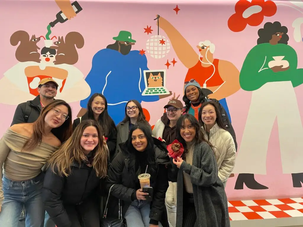 group of people in front of mural