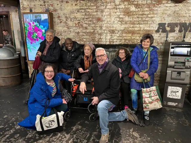 a group of people sitting posing for the camera at Chelsea Market in NYC