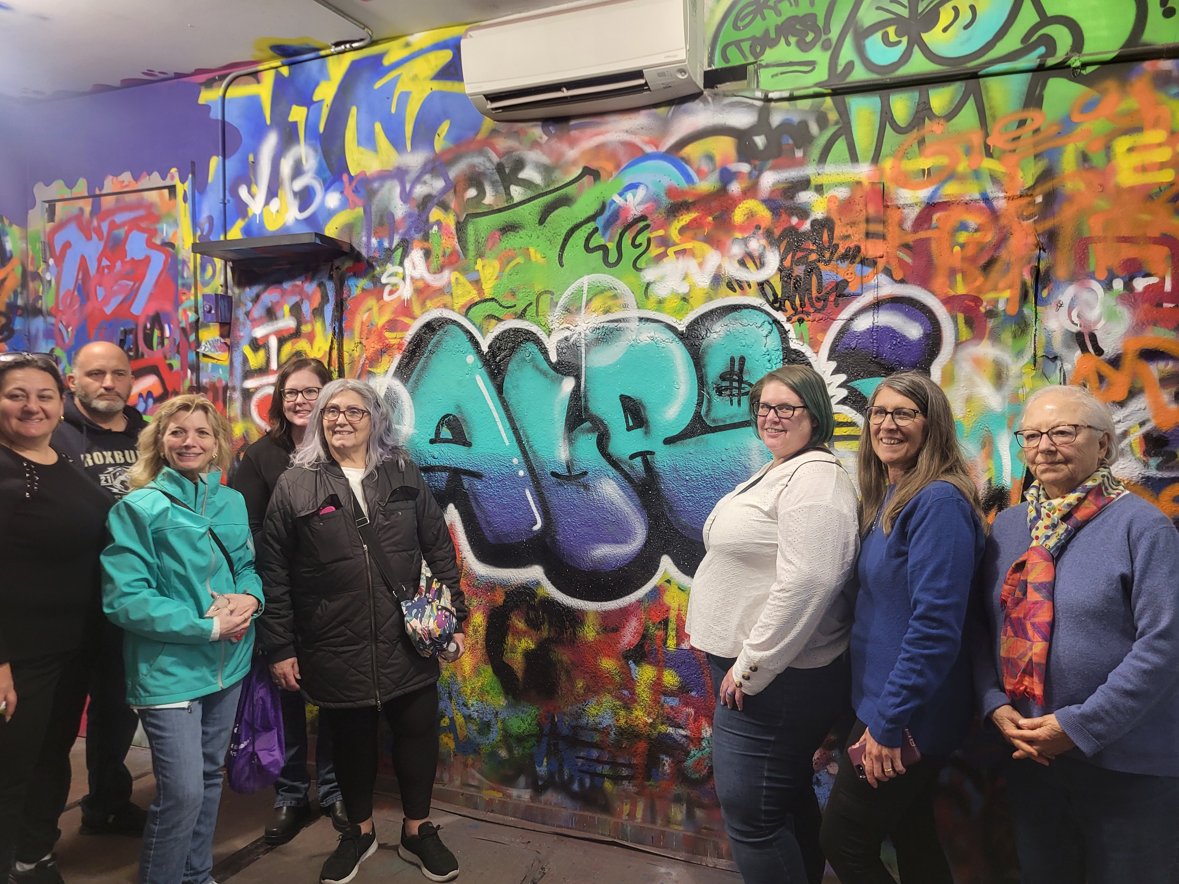 people smiling in front of art they did