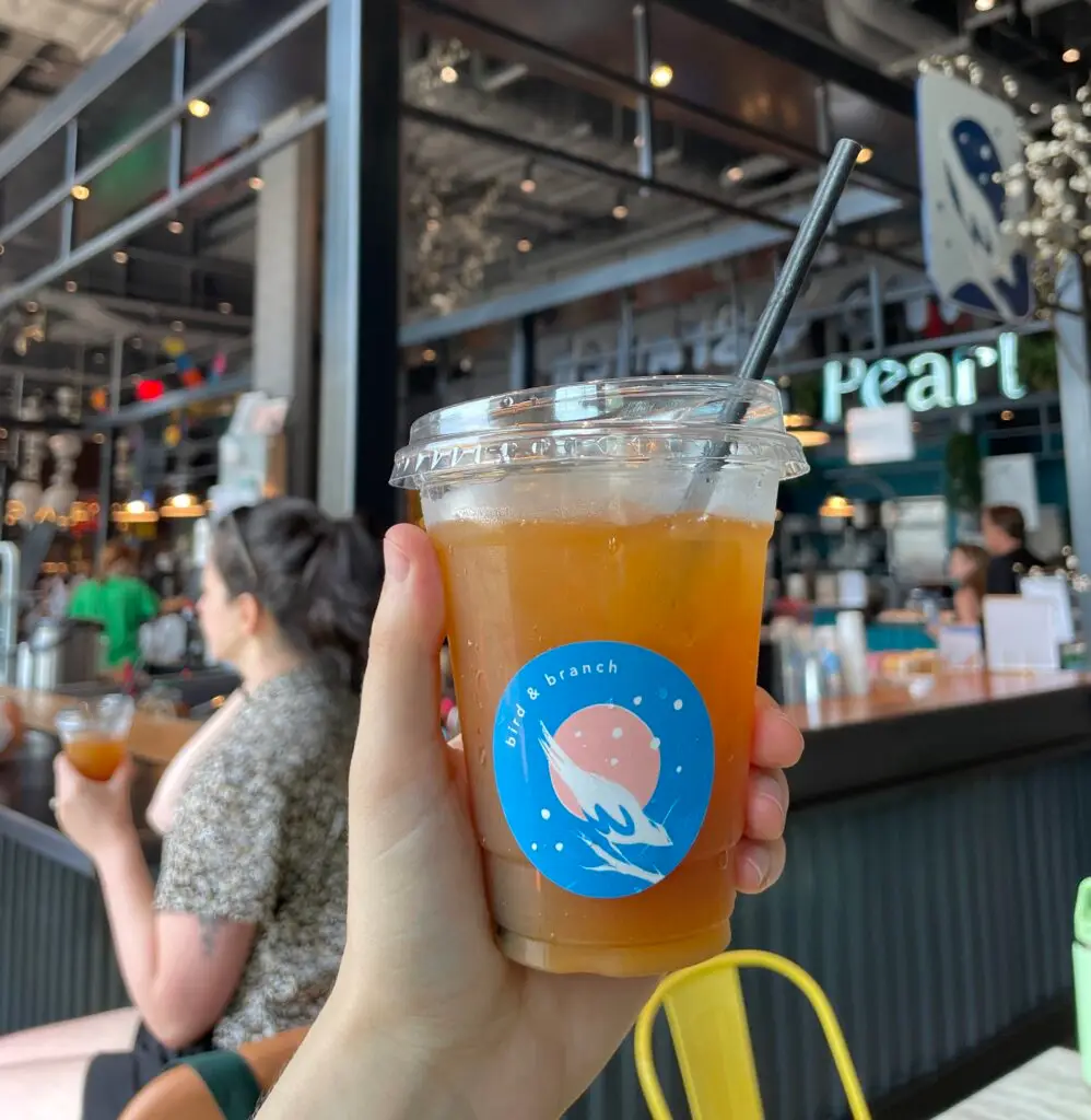 Passion fruit iced tea beverage being held up