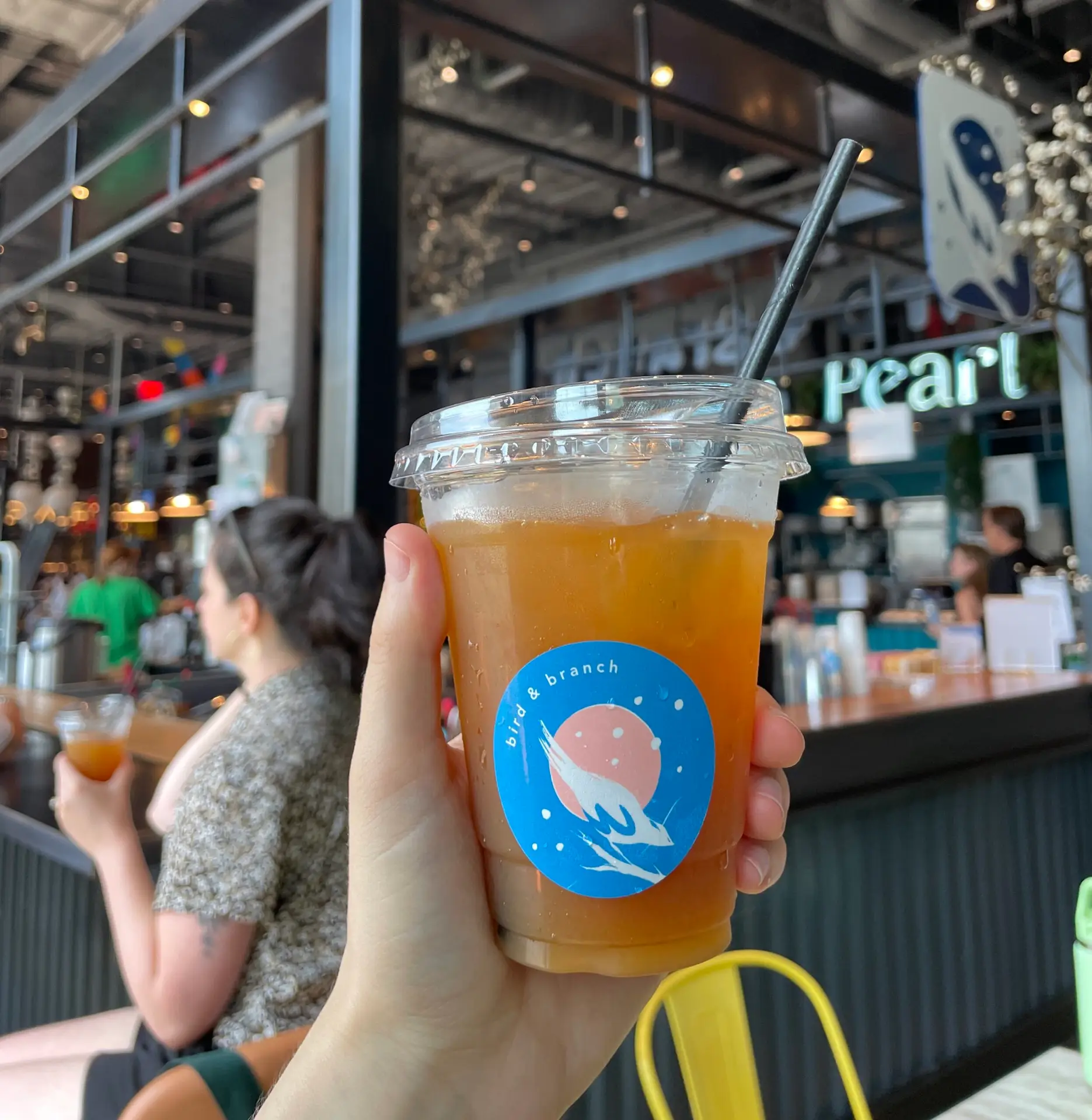 Passion fruit iced tea beverage being held up