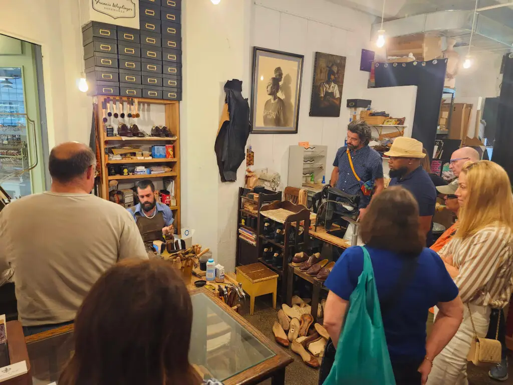 A group watches a shoemaking demonstration
