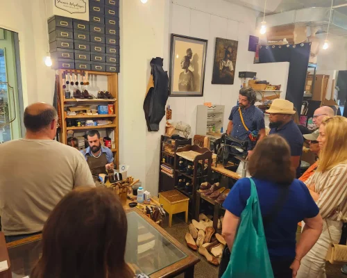 A group watches a shoemaking demonstration