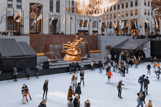 a group of people riding skis on top of Rockefeller Center