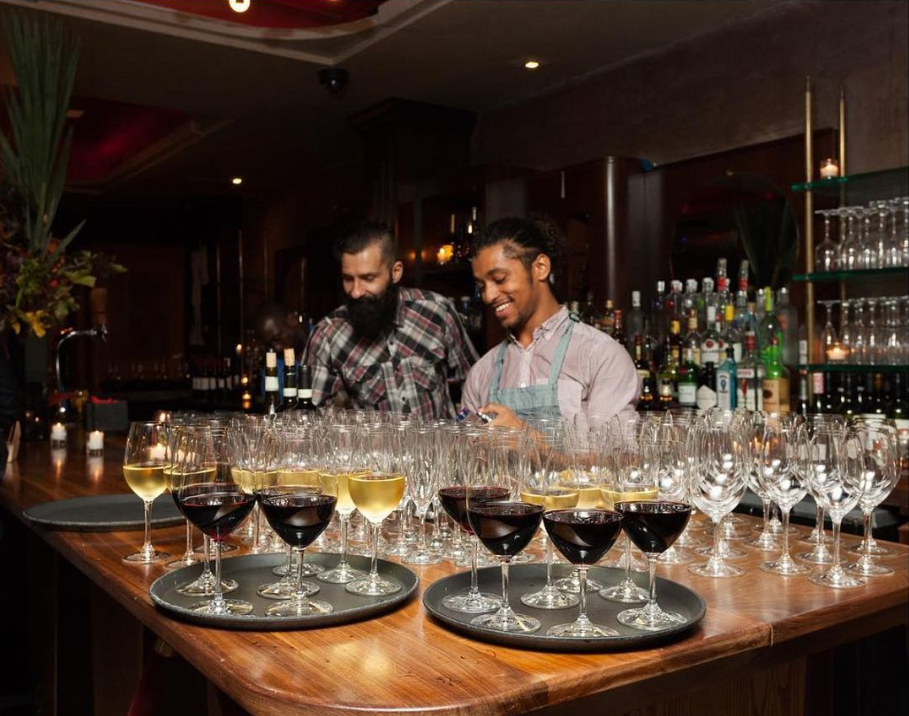 a person sitting at a table with wine glasses