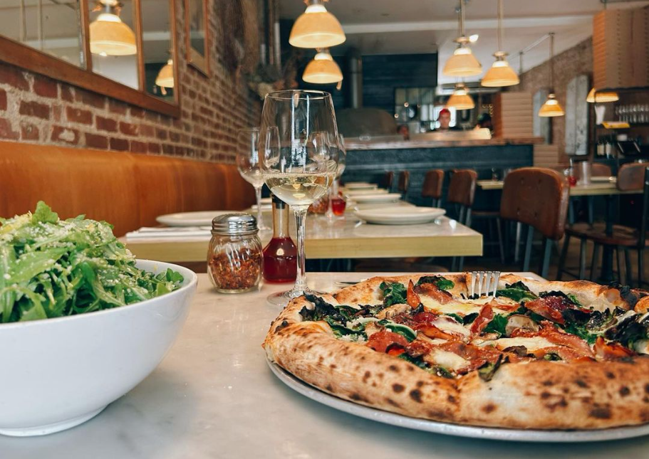 a pizza sitting on top of a plate of food on a table